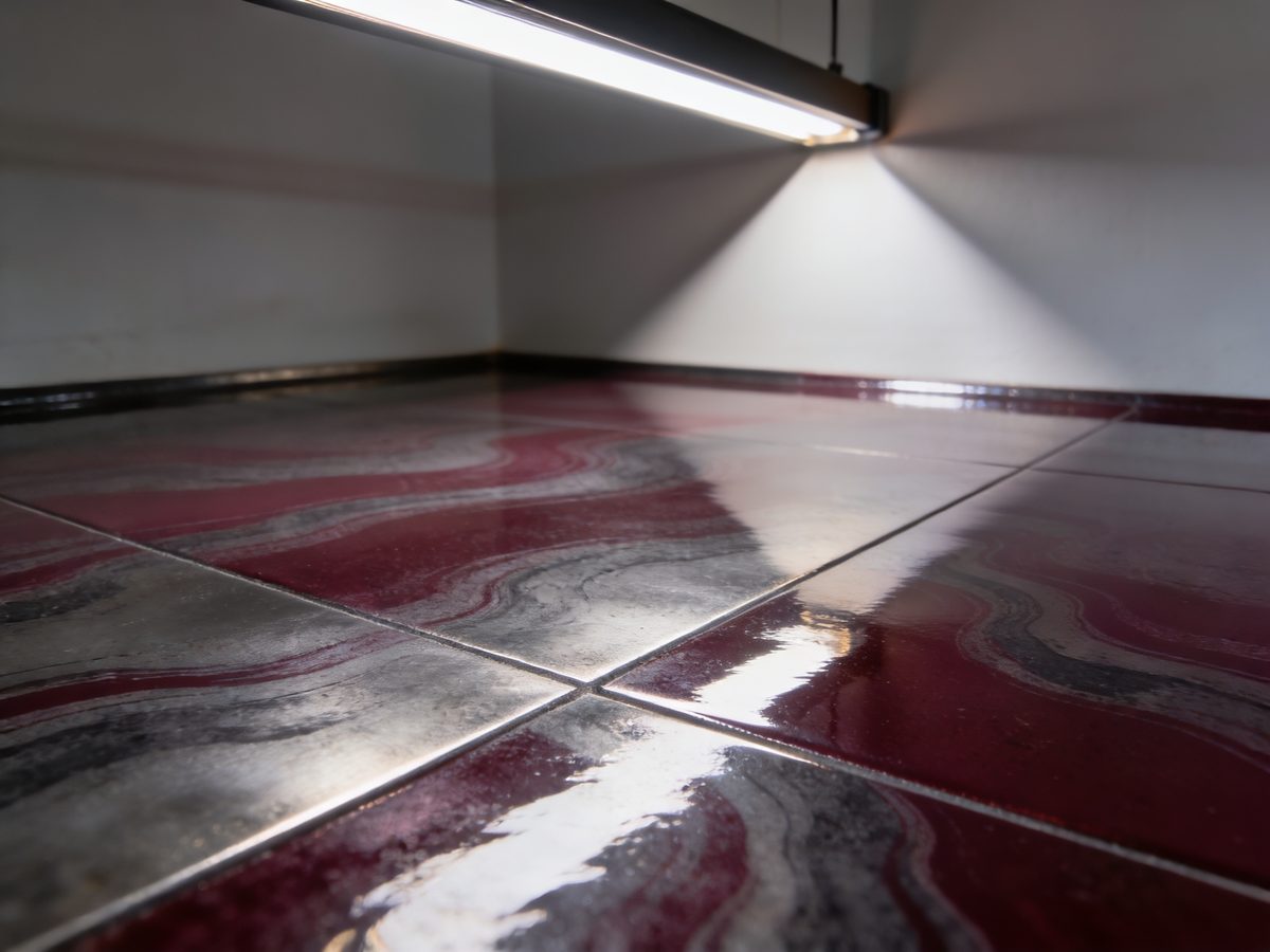 A metallic epoxy floor in oxblood and graphite pigments under a high-gloss topcoat